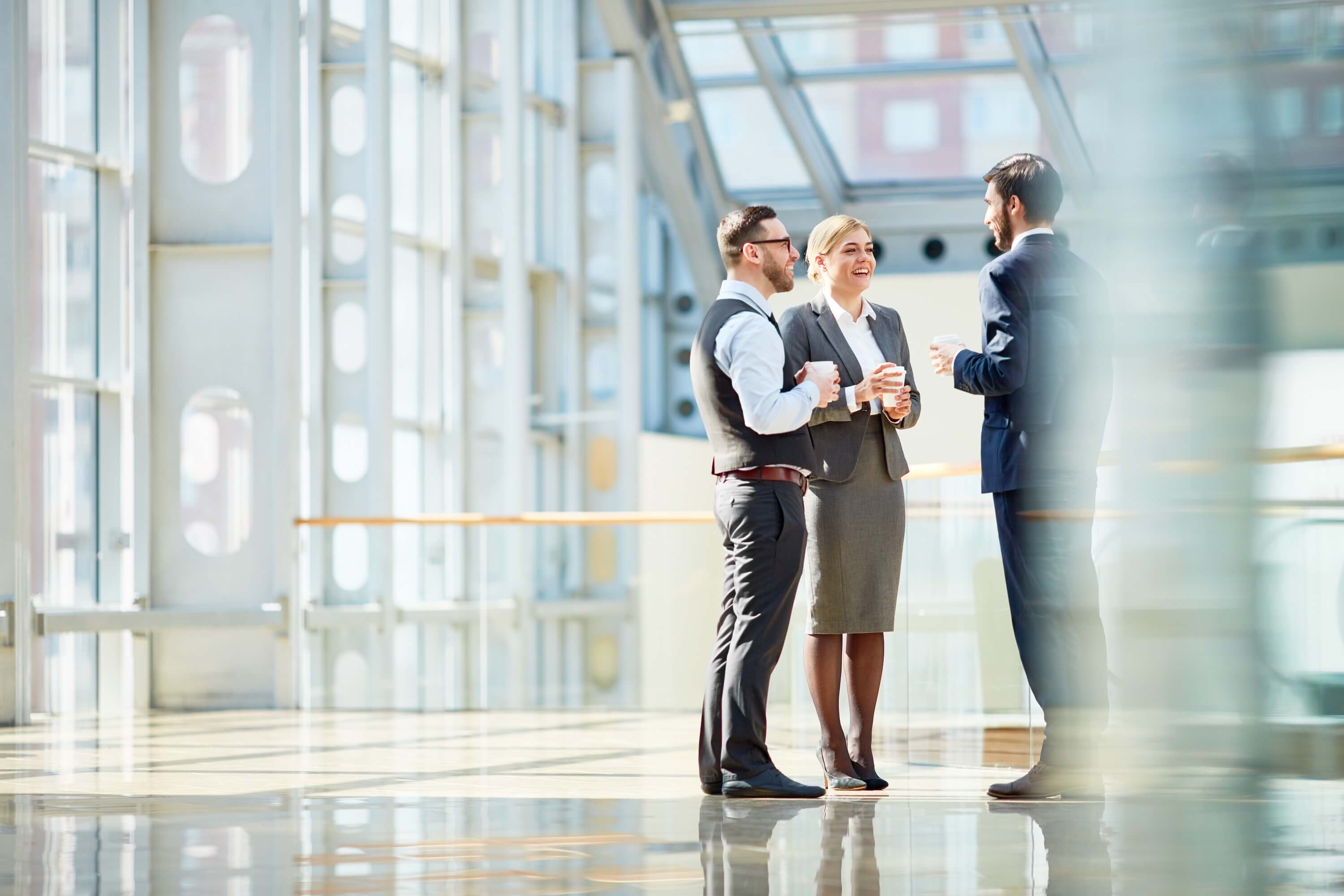 3-people-standing-in-a-entrance-talking-wearing-suits