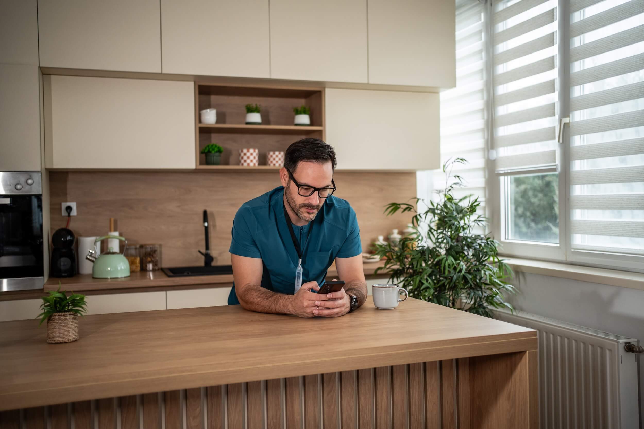 nurse-using-mobile-phone-in-a-kitchen-space
